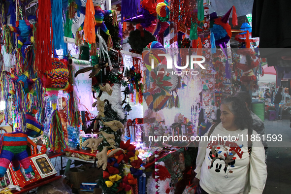 A woman walks past a stand where various items are sold for the Christmas season in the Tlalpan Center in Mexico City, Mexico, on December 7...