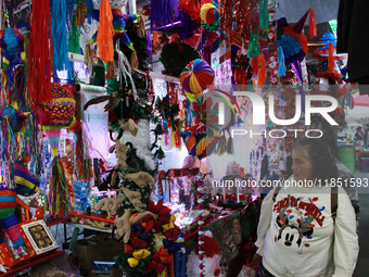 A woman walks past a stand where various items are sold for the Christmas season in the Tlalpan Center in Mexico City, Mexico, on December 7...