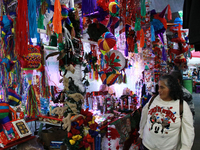 A woman walks past a stand where various items are sold for the Christmas season in the Tlalpan Center in Mexico City, Mexico, on December 7...