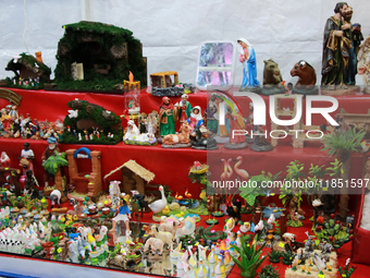 Figures for a nativity scene are available in a market where various products are sold for the Christmas season and the posadas, located in...