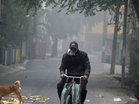 A newspaper delivery man delivers newspapers to houses on a cold and foggy day in Siliguri, India, on December 10, 2024. (