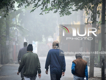 People travel to work and students go to school on a cold and foggy day in Siliguri, India, on December 10, 2024. (