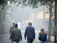 People travel to work and students go to school on a cold and foggy day in Siliguri, India, on December 10, 2024. (