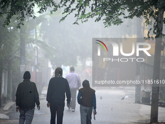 People travel to work and students go to school on a cold and foggy day in Siliguri, India, on December 10, 2024. (