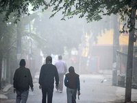 People travel to work and students go to school on a cold and foggy day in Siliguri, India, on December 10, 2024. (