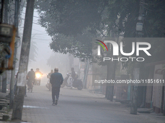 People travel to work and students go to school on a cold and foggy day in Siliguri, India, on December 10, 2024. (