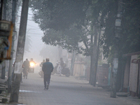 People travel to work and students go to school on a cold and foggy day in Siliguri, India, on December 10, 2024. (