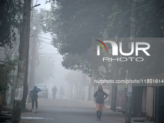 People travel to work and students go to school on a cold and foggy day in Siliguri, India, on December 10, 2024. (