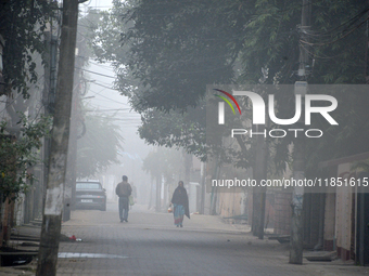 People travel to work and students go to school on a cold and foggy day in Siliguri, India, on December 10, 2024. (