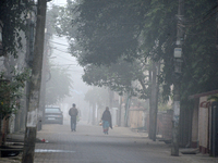 People travel to work and students go to school on a cold and foggy day in Siliguri, India, on December 10, 2024. (