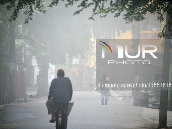 People travel to work and students go to school on a cold and foggy day in Siliguri, India, on December 10, 2024. (