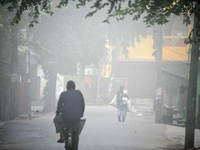 People travel to work and students go to school on a cold and foggy day in Siliguri, India, on December 10, 2024. (