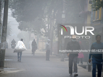 People travel to work and students go to school on a cold and foggy day in Siliguri, India, on December 10, 2024. (