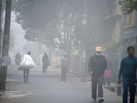 People travel to work and students go to school on a cold and foggy day in Siliguri, India, on December 10, 2024. (