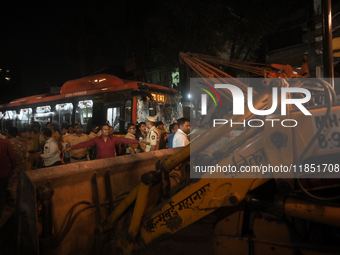 People are seen near an accident site where a BEST bus loses control and crushes a few vehicles, injuring 49 people and killing 7 people in...