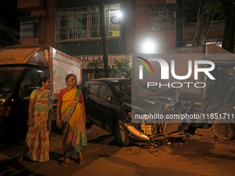 Pedestrians are near a damaged car where a BEST bus loses control and crushes a few vehicles, injuring 49 people and killing 7 people in Mum...