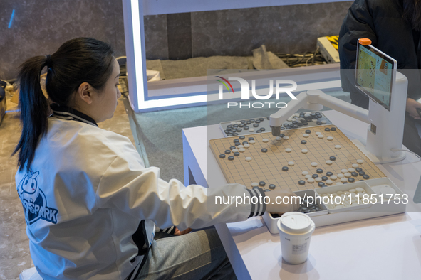 A visitor interacts with a Go robot at the 2024 Global Artificial Intelligence Product Application Expo in Suzhou, China, on December 10, 20...