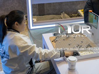 A visitor interacts with a Go robot at the 2024 Global Artificial Intelligence Product Application Expo in Suzhou, China, on December 10, 20...