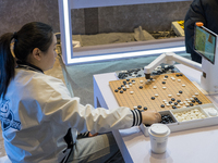 A visitor interacts with a Go robot at the 2024 Global Artificial Intelligence Product Application Expo in Suzhou, China, on December 10, 20...