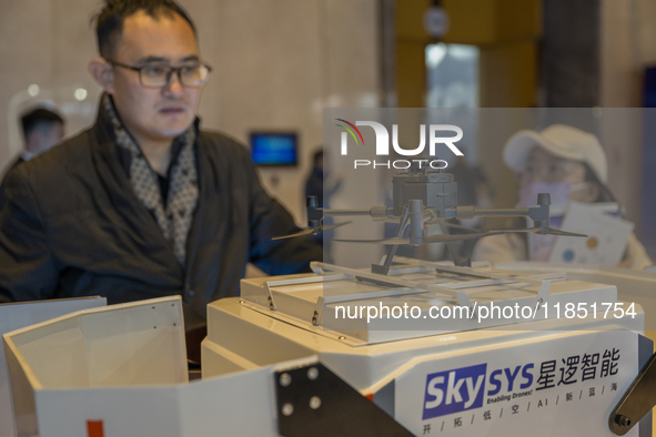 A visitor looks at a patrol drone at the 2024 Global Artificial Intelligence Product Application Expo in Suzhou, China, on December 10, 2024...