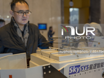 A visitor looks at a patrol drone at the 2024 Global Artificial Intelligence Product Application Expo in Suzhou, China, on December 10, 2024...