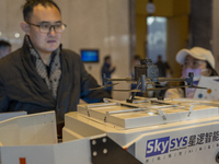 A visitor looks at a patrol drone at the 2024 Global Artificial Intelligence Product Application Expo in Suzhou, China, on December 10, 2024...