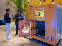 Visitors look at an automatic pet bathing pod at the 2024 Global Artificial Intelligence Product Application Expo in Suzhou, China, on Decem...