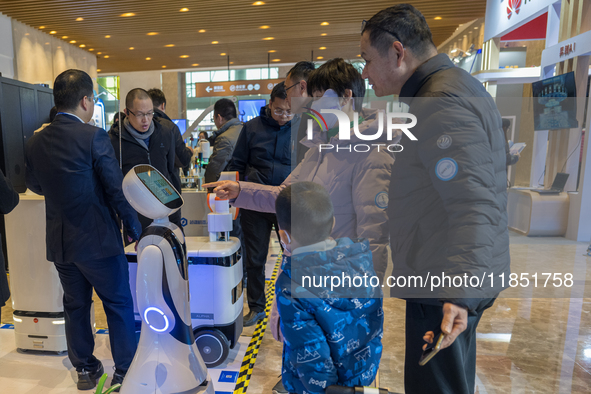 Visitors look at robot products at the 2024 Global Artificial Intelligence Product Application Expo in Suzhou, China, on December 10, 2024. 