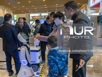 Visitors look at robot products at the 2024 Global Artificial Intelligence Product Application Expo in Suzhou, China, on December 10, 2024....