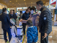 Visitors look at robot products at the 2024 Global Artificial Intelligence Product Application Expo in Suzhou, China, on December 10, 2024....