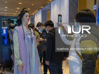 Visitors look at robot products at the 2024 Global Artificial Intelligence Product Application Expo in Suzhou, China, on December 10, 2024....