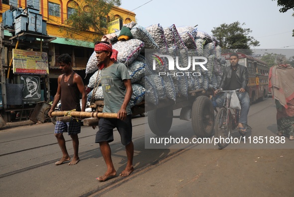 Labourers transport garlic sacks in a handcart at a wholesale market before moving them to a retail market in Kolkata, India, on December 10...