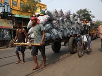 Labourers transport garlic sacks in a handcart at a wholesale market before moving them to a retail market in Kolkata, India, on December 10...