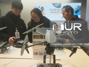 Customers shop for a new aerial drone at a DJI store in Hangzhou, China, on December 10, 2024. (