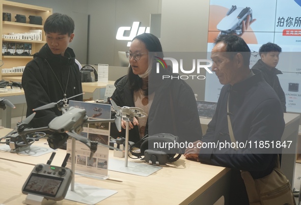 Customers shop for a new aerial drone at a DJI store in Hangzhou, China, on December 10, 2024. 