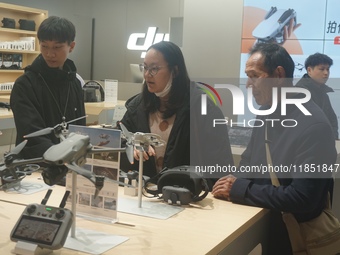 Customers shop for a new aerial drone at a DJI store in Hangzhou, China, on December 10, 2024. (