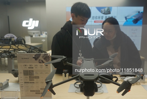 Customers shop for a new aerial drone at a DJI store in Hangzhou, China, on December 10, 2024. 