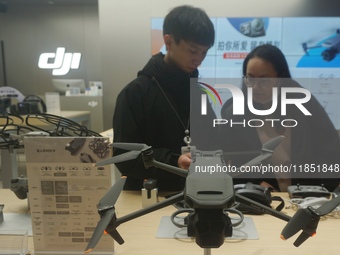 Customers shop for a new aerial drone at a DJI store in Hangzhou, China, on December 10, 2024. (