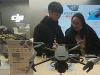 Customers shop for a new aerial drone at a DJI store in Hangzhou, China, on December 10, 2024. (