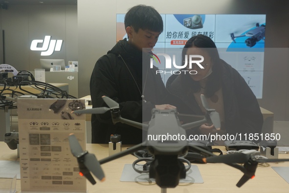 Customers shop for a new aerial drone at a DJI store in Hangzhou, China, on December 10, 2024. 