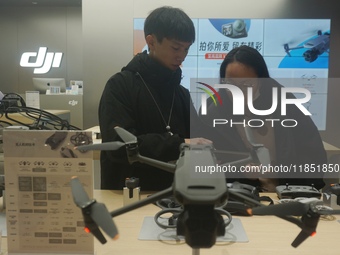 Customers shop for a new aerial drone at a DJI store in Hangzhou, China, on December 10, 2024. (