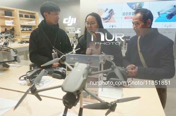 Customers shop for a new aerial drone at a DJI store in Hangzhou, China, on December 10, 2024. 