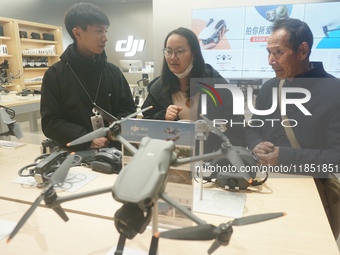 Customers shop for a new aerial drone at a DJI store in Hangzhou, China, on December 10, 2024. (