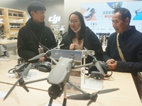 Customers shop for a new aerial drone at a DJI store in Hangzhou, China, on December 10, 2024. (