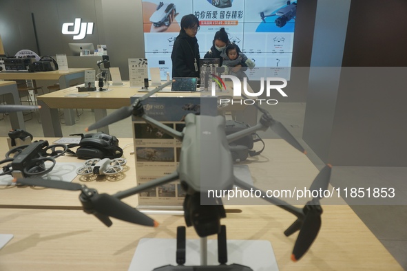 Customers shop for a new aerial drone at a DJI store in Hangzhou, China, on December 10, 2024. 