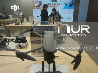 Customers shop for a new aerial drone at a DJI store in Hangzhou, China, on December 10, 2024. (