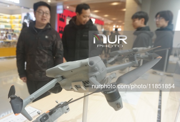 Customers shop for a new aerial drone at a DJI store in Hangzhou, China, on December 10, 2024. 