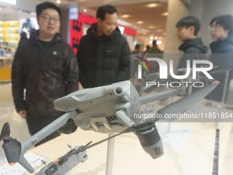 Customers shop for a new aerial drone at a DJI store in Hangzhou, China, on December 10, 2024. (