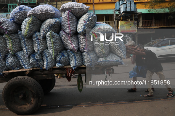 Labourers transport garlic sacks in a handcart at a wholesale market before moving them to a retail market in Kolkata, India, on December 10...