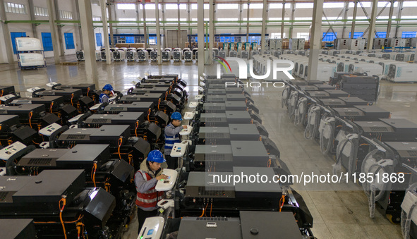 Workers debug smart mobile charging piles at Nantong Guoxuan New Energy Technology Co., LTD., located in Nantong High-tech Zone, East China'...